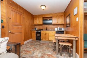 una cocina con armarios de madera y una mesa con sillas. en Shore Meadows Lodge LLC, en Lake George