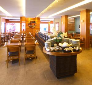 restauracja ze stołami, krzesłami i talerzami na wystawie w obiekcie Malibu Palace Hotel w mieście Cabo Frio