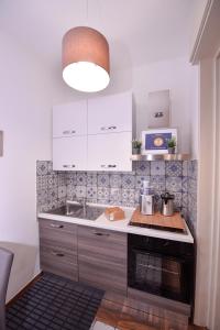 una cucina con lavello e fornello forno superiore di Symposium Bed&Breakfast a Catania
