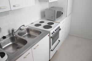 uma cozinha com um lavatório, um fogão e um micro-ondas em Jokihovi em Nivala