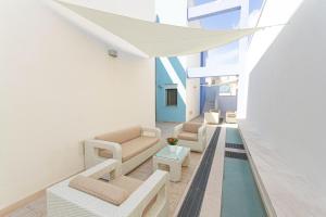 a living room with white furniture and a pool at Residence Borgo & Mare - Localo in Melendugno