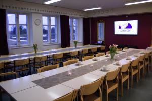 a large room with tables and chairs and a screen at Jokihovi in Nivala