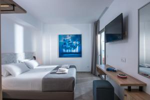 a bedroom with a bed and a desk and a tv at Villa Diktynna in Hersonissos