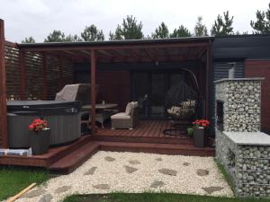 a deck with a hot tub and a grill at Domek SunRelax z jacuzzi niedaleko Suntago in Korytów