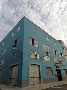 un edificio azul con cuatro puertas de garaje en el lateral en Suite Trujillo, en Trujillo