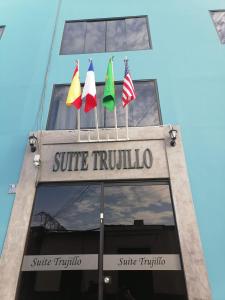 un edificio con cuatro banderas encima en Suite Trujillo en Trujillo