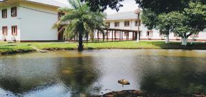 une maison avec un étang en face d'un bâtiment dans l'établissement Hotel Vila Rica Belém, à Belém