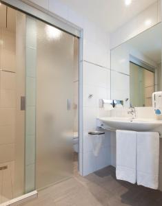 a bathroom with a shower and a sink at Landzeit Motor-Hotel Mondsee in Mondsee