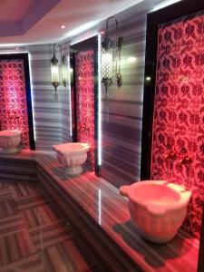 a bathroom with three sinks in a room with red lights at Lavinia Apart & Hotel in Alanya