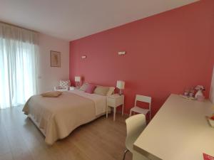 ein rotes Schlafzimmer mit einem Bett, einem Tisch und Stühlen in der Unterkunft Dimora Francesca in Conversano