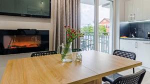 a dining room table with a vase of flowers on it at Apartament San in Łeba