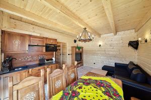 a room with a kitchen and a living room with a bed at Chatka u Górala in Jurgów