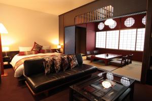 Habitación de hotel con cama y sofá en Kizashi The Suite 京都祇園, en Kioto