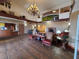 een lobby met een tafel en stoelen en een kroonluchter bij Quality Inn & Suites Wellington – Fort Collins in Wellington