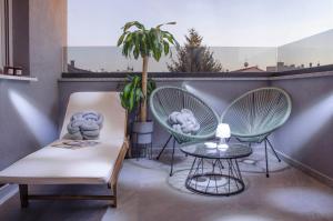 uma varanda com duas cadeiras, uma mesa e uma planta em Villa Kap em Zagreb