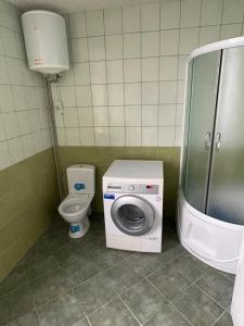 a bathroom with a washing machine and a toilet at Nuomojami kambariai Kelmeje in Kelmė