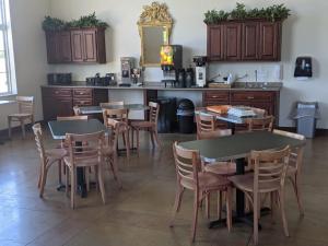 a dining room with tables and chairs and a counter at Heritage Inn and Suites in Amory