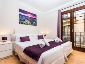 una camera da letto con un grande letto bianco e una finestra di Mallorca Suites - Turismo de Interior a Palma de Mallorca