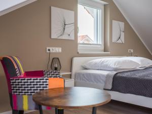 a bedroom with a bed and a table and a chair at Naturpark-5 Sterne Ferienhaus-Kamin-Sauna-See in Krakow am See
