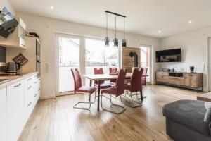 a kitchen and dining room with a table and chairs at Naturpark-5 Sterne Ferienhaus-Kamin-Sauna-See in Krakow am See