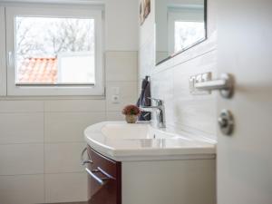 a bathroom with a sink and a window at Naturpark-5 Sterne Ferienhaus-Kamin-Sauna-See in Krakow am See +25 photos