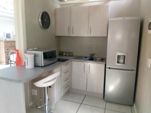 a kitchen with a white refrigerator and a microwave at LaPlek Guest Suite in East London