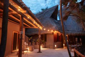 a house with a thatched roof with lights on it at Casa Nalum in Tulum