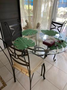a glass table with a chair and a glass table with leaves at appartement à Cannes in Cannes