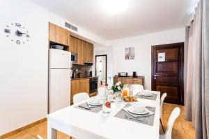 eine Küche mit einem weißen Tisch und einem weißen Kühlschrank in der Unterkunft Mallorca Suites - Turismo de Interior in Palma de Mallorca