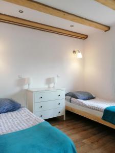 a bedroom with two beds and a white dresser at Apartamenty Pod Lipą in Lutowiska