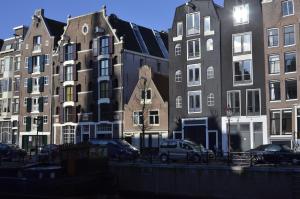 un grupo de edificios con coches estacionados frente a ellos en Bed & Breakfast of Art, en Ámsterdam