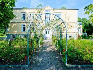 einen Torbogen in einem Garten vor einem Gebäude in der Unterkunft Gutshaus Landsdorf in Landsdorf