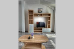 ein Wohnzimmer mit einem Tisch und einem TV in der Unterkunft New and modern, 2 rooms cozy apartment in Timişoara