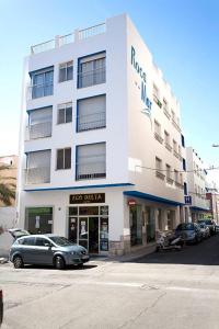 a white building with a car parked in front of it at Nou Rocamar in Sant Carles de la Ràpita