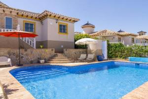 een zwembad voor een huis bij Casa Lilly-Rose, a beautiful 3 bedroom detached villa a short walk to the Villamartin Plaza & Golf course in Villamartin