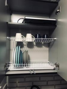 a shelf with cups and plates on it in a kitchen at Iren Smart Apartment in Lviv