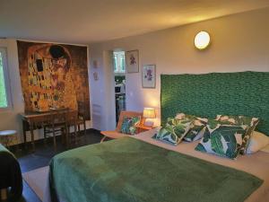 1 dormitorio con cama verde y comedor en La Citadelle, en Sainte-Geneviève-lès-Gasny