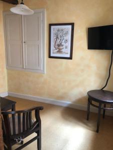 a room with a chair and a television on a wall at Altstadtmeise Rustika in Meisenheim