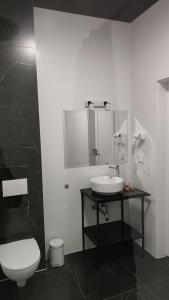 a white bathroom with a sink and a toilet at Hotel ANTARES in Sępólno Krajeńskie