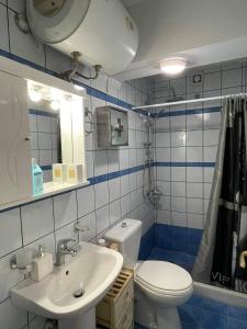 uma casa de banho azul e branca com um WC e um lavatório em Blue Lagoon Studio em Mesolongion