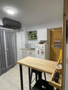 uma cozinha com uma mesa de madeira e um frigorífico branco em Blue Lagoon Studio em Mesolongion