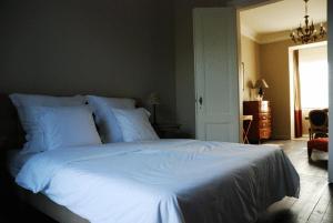 una camera da letto con un grande letto con lenzuola bianche di B&B Villa des Roses a Hasselt