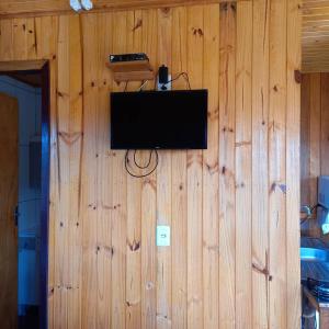 TV de pantalla plana en una pared de madera en Chalés Vista Bonita, en Urubici