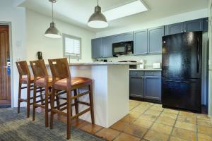 a kitchen with blue cabinets and a black refrigerator at Starr Pass Golf Suites in Tucson