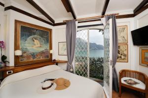 um quarto com uma cama e uma grande janela em Villa Oliver - Breathtaking small Pool 14 sqm Hydromassage on the Rock - Amalfi Coast em Amalfi
