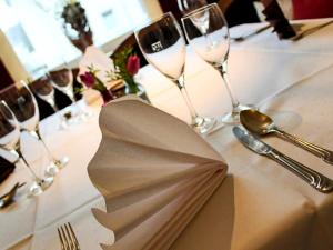 a table with wine glasses and a napkin on it at Jetenburger Hof in Bückeburg