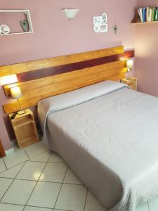 オルビアにあるB&B A CASA DI MONICAのベッドルーム1室(大型ベッド1台、木製ヘッドボード付)