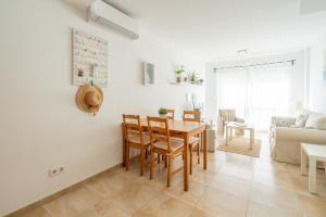 a dining room and living room with a table and chairs at Casa Colonia in Colònia de Sant Jordi