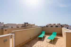 two green chairs sitting on a roof at Casa Colonia in Colonia Sant Jordi