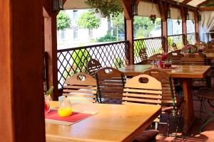 un restaurante con mesas de madera y sillas en el balcón en Jetenburger Hof, en Bückeburg